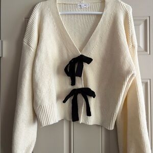 Elegant Cream Sweater with Black Accent bows.